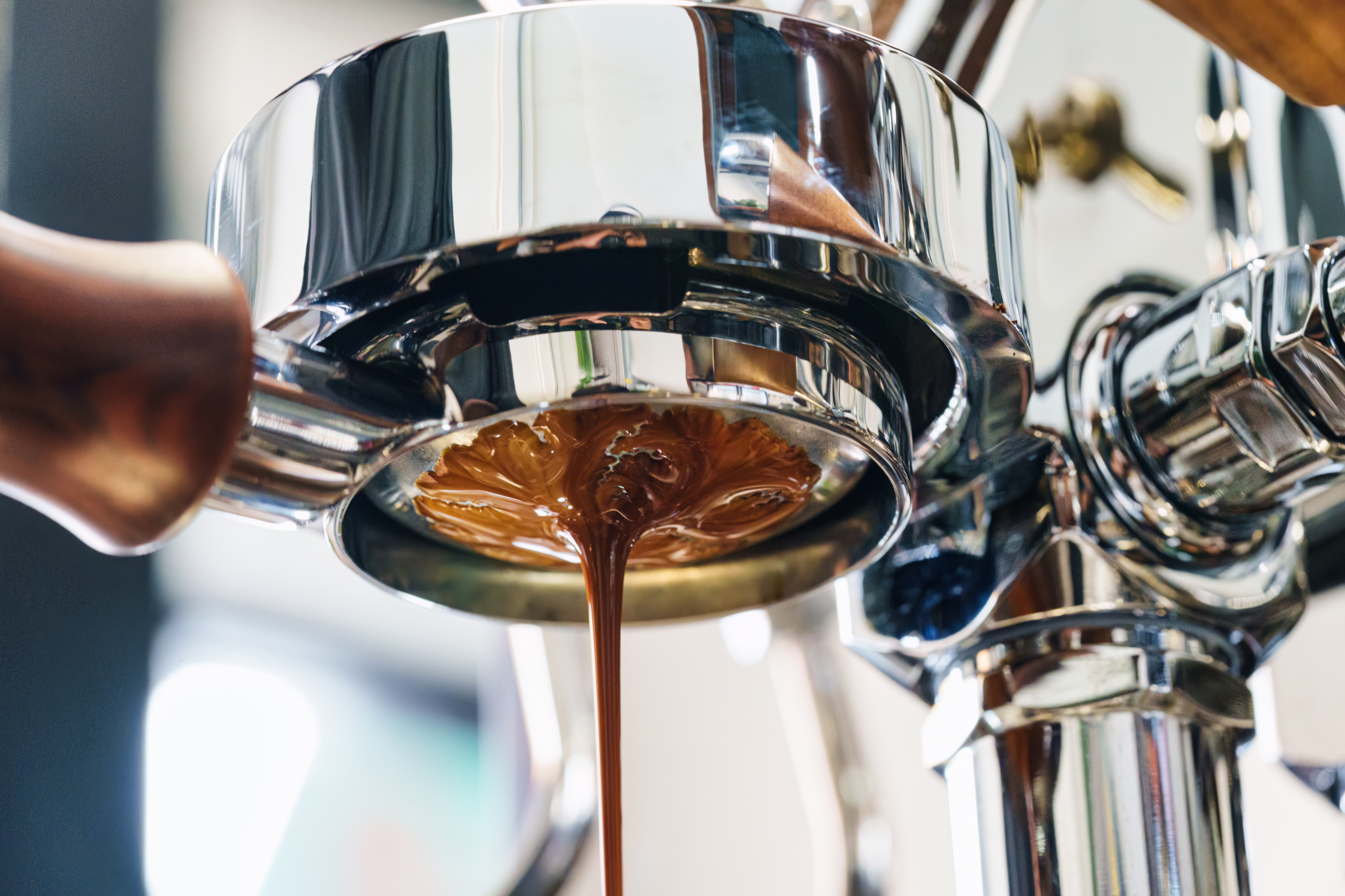 Nahansicht Siebträger von unten. Espresso läuft heraus